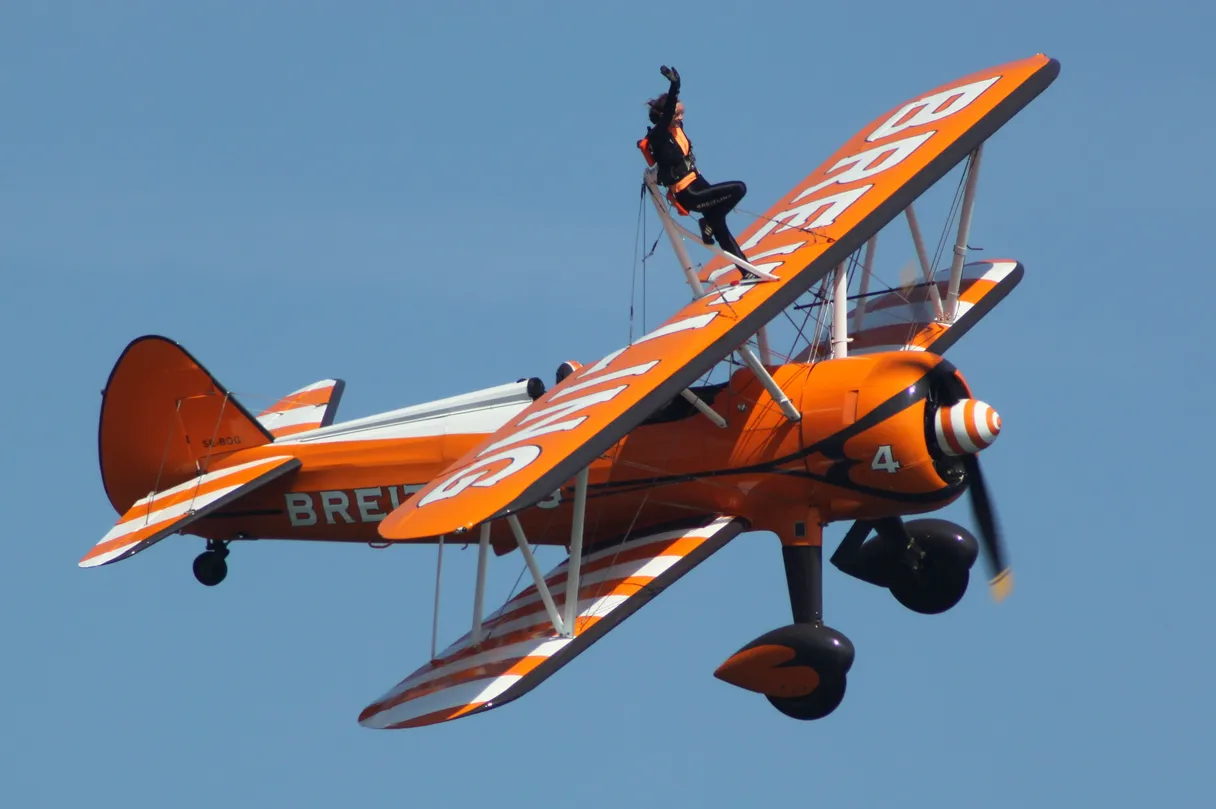 Wing walker performing on a biplane in flight